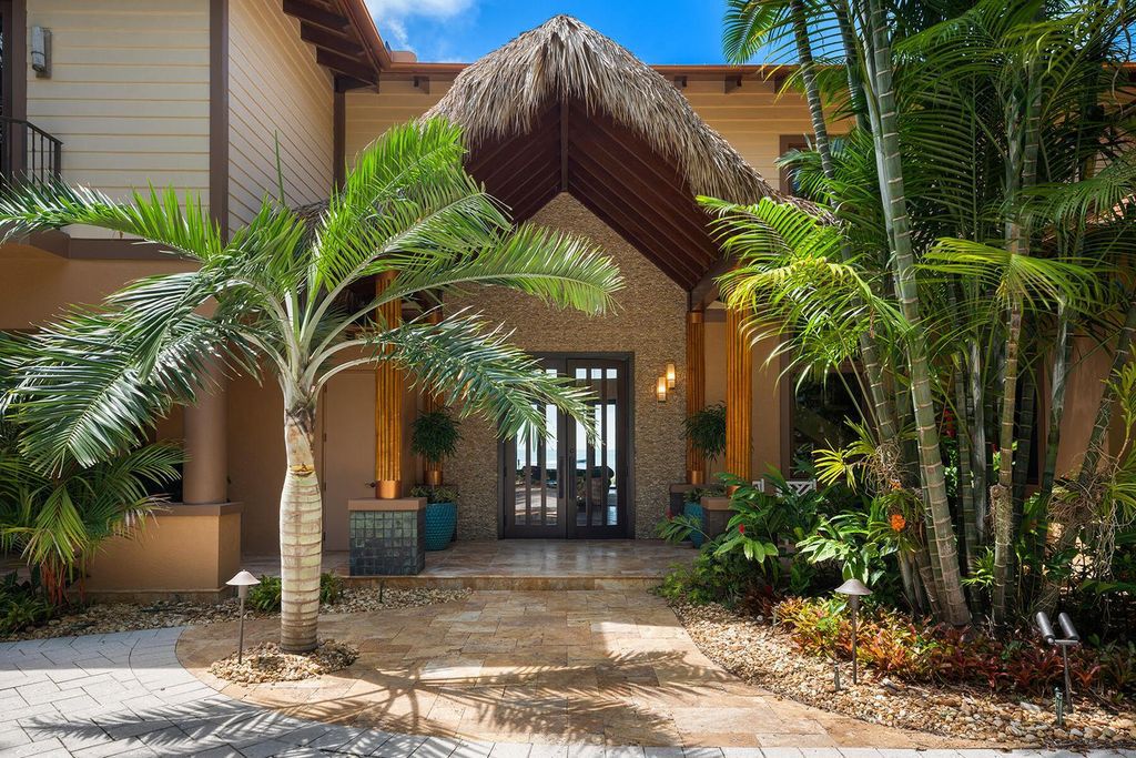This exquisite bayfront property features a main home with four bedrooms, four full bathrooms, and two half bathrooms, plus a guest house with two bedrooms and one bathroom.