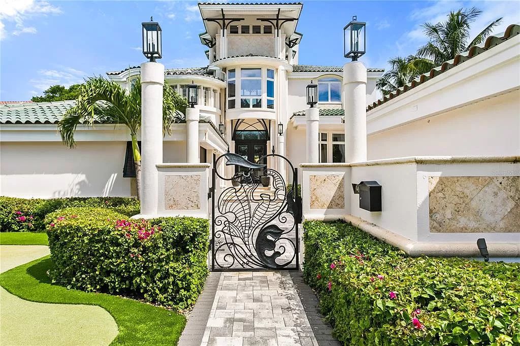 Welcome to 420 Coffee Pot Riviera NE, Saint Petersburg, Florida 33704 - an exquisite estate on a half-acre lot along Tampa Bay. Enter through vine-inspired wrought iron gates to a home that seamlessly blends organic, nature-inspired design with unique architectural elements.