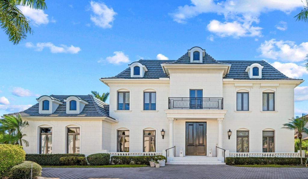 This 6-bedroom, 6.5-bathroom masterpiece, inspired by classic European estates, boasts soaring ceilings, a sweeping staircase, and grand living spaces including formal living and dining rooms, a den, and a separate bar.