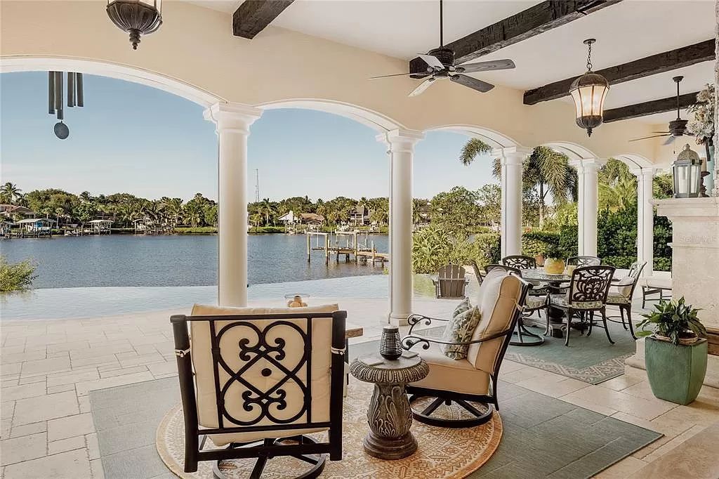 Located on a picturesque, tree-lined street, this Mediterranean-inspired custom waterfront home by P B Built is a true gem.