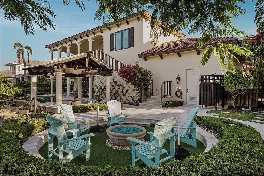 Located on a picturesque, tree-lined street, this Mediterranean-inspired custom waterfront home by P B Built is a true gem.