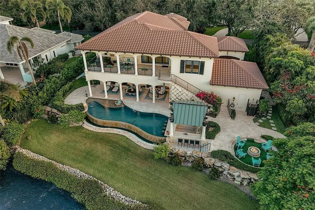 Located on a picturesque, tree-lined street, this Mediterranean-inspired custom waterfront home by P B Built is a true gem.