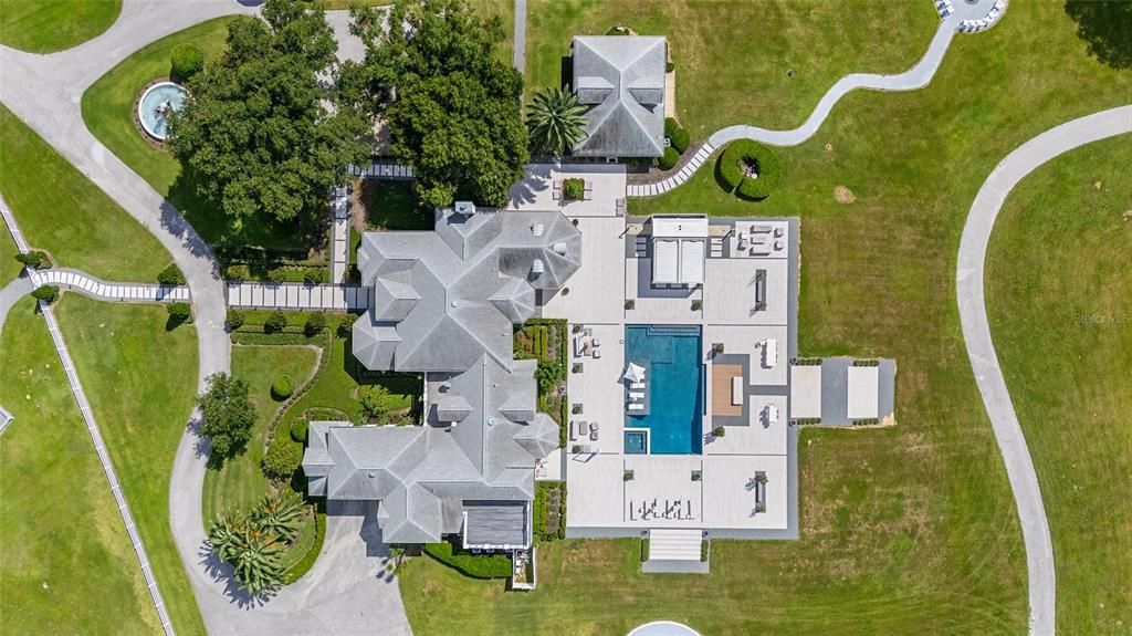 This 10,000 square feet main residence features 8 bedrooms, including separate caretaker's quarters, and boasts a grand foyer with 20-foot ceilings, a gourmet kitchen, and ample entertainment space.