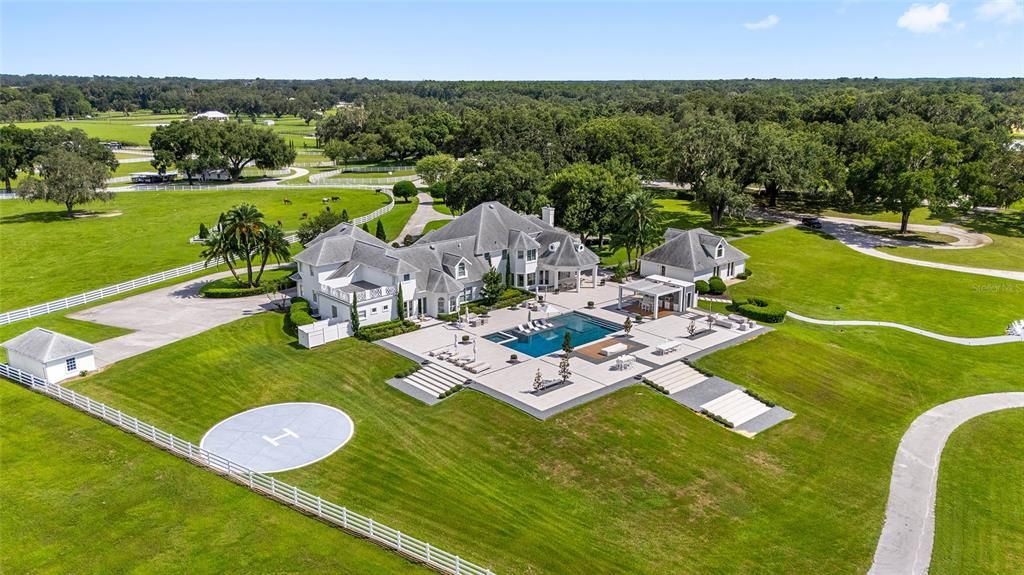 This 10,000 square feet main residence features 8 bedrooms, including separate caretaker's quarters, and boasts a grand foyer with 20-foot ceilings, a gourmet kitchen, and ample entertainment space.