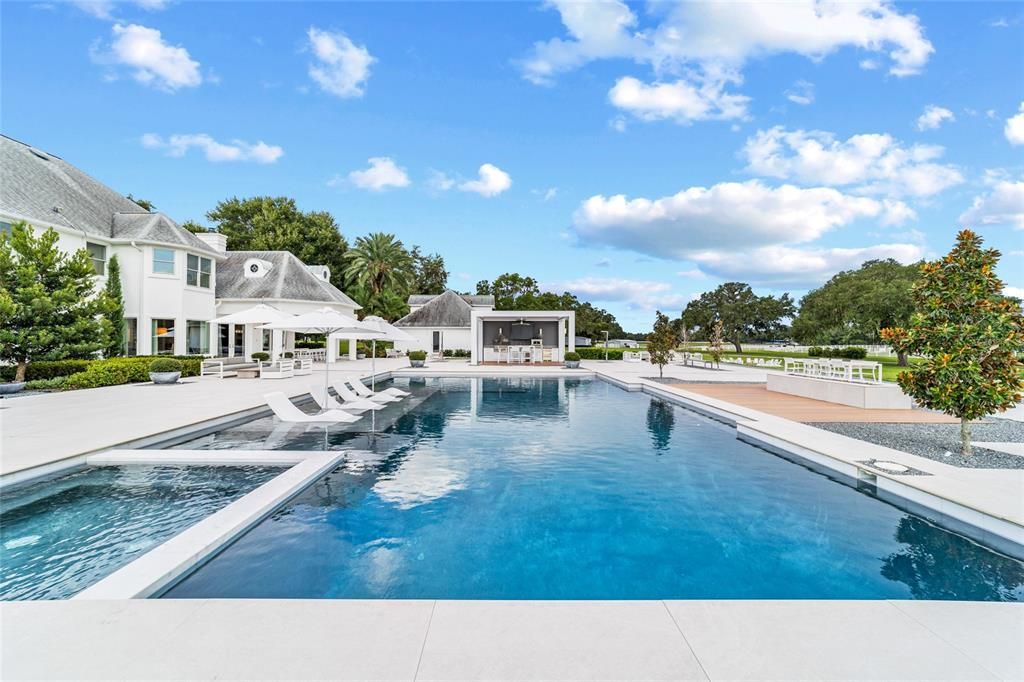 This 10,000 square feet main residence features 8 bedrooms, including separate caretaker's quarters, and boasts a grand foyer with 20-foot ceilings, a gourmet kitchen, and ample entertainment space.