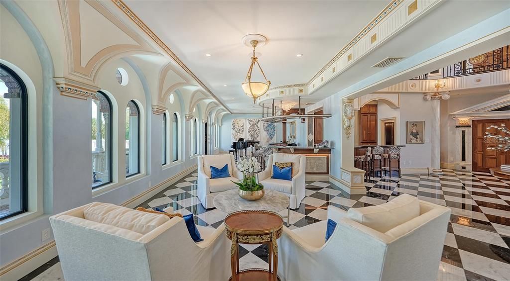 Featuring imported marble floors, Venetian plaster walls, and gold leaf moldings, the residence exudes Old World elegance. Enjoy breathtaking sunsets from terraces, gardens, or the Versace-inspired pool area.