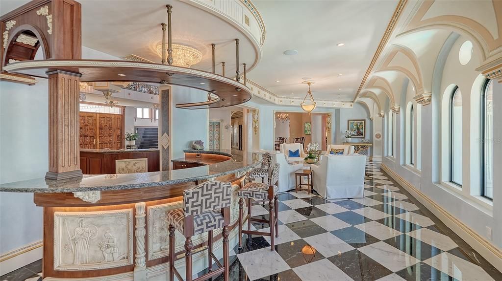 Featuring imported marble floors, Venetian plaster walls, and gold leaf moldings, the residence exudes Old World elegance. Enjoy breathtaking sunsets from terraces, gardens, or the Versace-inspired pool area.