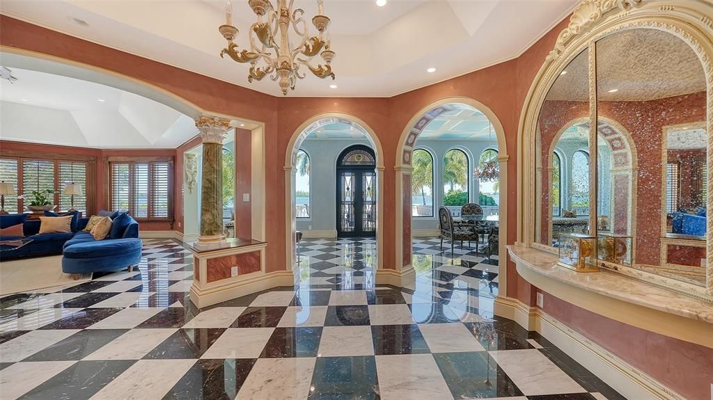 Featuring imported marble floors, Venetian plaster walls, and gold leaf moldings, the residence exudes Old World elegance. Enjoy breathtaking sunsets from terraces, gardens, or the Versace-inspired pool area.