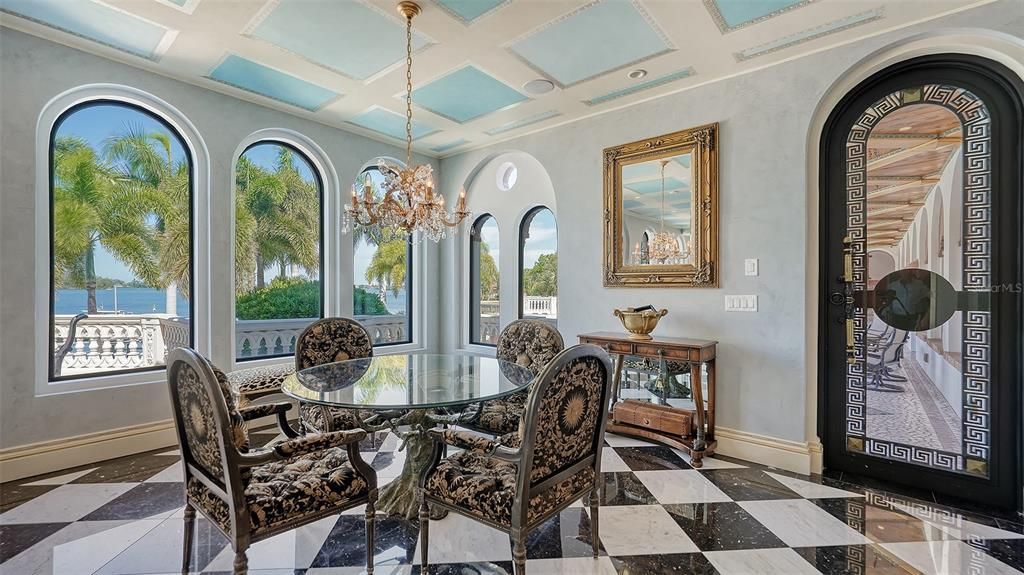 Featuring imported marble floors, Venetian plaster walls, and gold leaf moldings, the residence exudes Old World elegance. Enjoy breathtaking sunsets from terraces, gardens, or the Versace-inspired pool area.