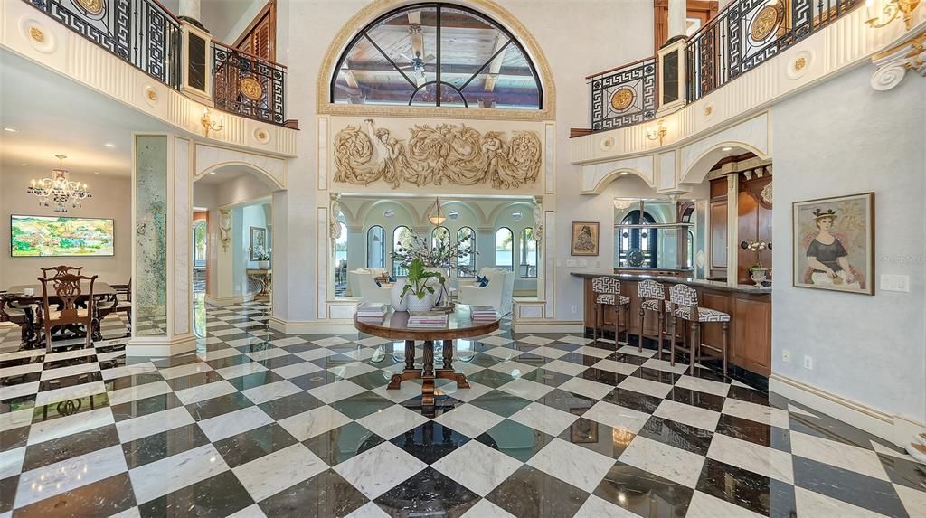 Featuring imported marble floors, Venetian plaster walls, and gold leaf moldings, the residence exudes Old World elegance. Enjoy breathtaking sunsets from terraces, gardens, or the Versace-inspired pool area.