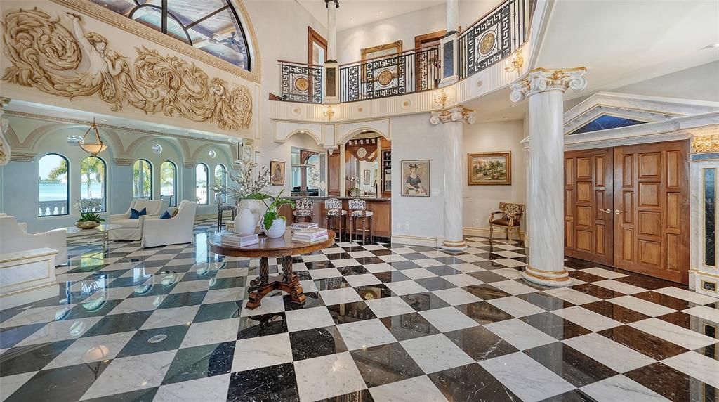 Featuring imported marble floors, Venetian plaster walls, and gold leaf moldings, the residence exudes Old World elegance. Enjoy breathtaking sunsets from terraces, gardens, or the Versace-inspired pool area.