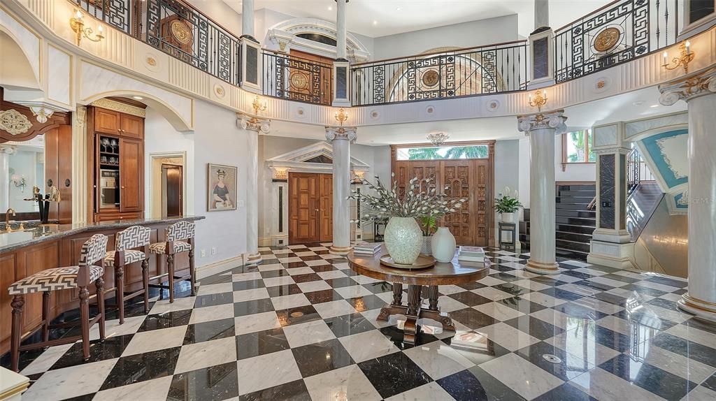 Featuring imported marble floors, Venetian plaster walls, and gold leaf moldings, the residence exudes Old World elegance. Enjoy breathtaking sunsets from terraces, gardens, or the Versace-inspired pool area.