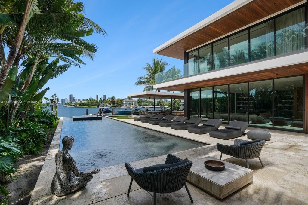 This 5-bed, 7-bath modern masterpiece at 126 W San Marino Dr boasts 90 ft of waterfront and downtown views.