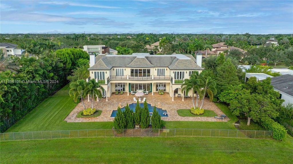 Set on 1 acre by a natural preserve, this 10,285 sq ft home offers luxurious living with marble and wood floors, a gourmet kitchen featuring a Wolf gas range, island, granite countertops, and two new Bosch dishwashers. Amenities include a home theater, game room, gym, sunroom, bar, and billiards room.