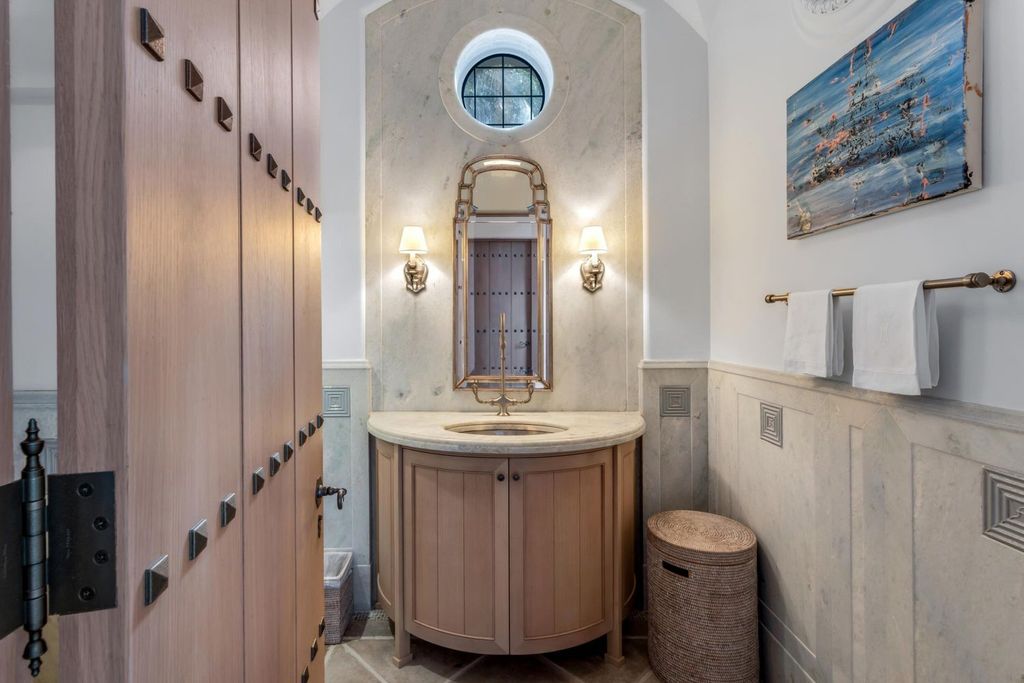 This stunning 8-bedroom, 9-bathroom estate spans 9,855 square feet and evokes the charm of Lake Como’s iconic villas. Designed by John Saladino, it blends rustic sophistication with grand elegance, featuring hand-hewn wood beams, reclaimed terra cotta floors, plaster walls, and a Tejas Borja tile roof.