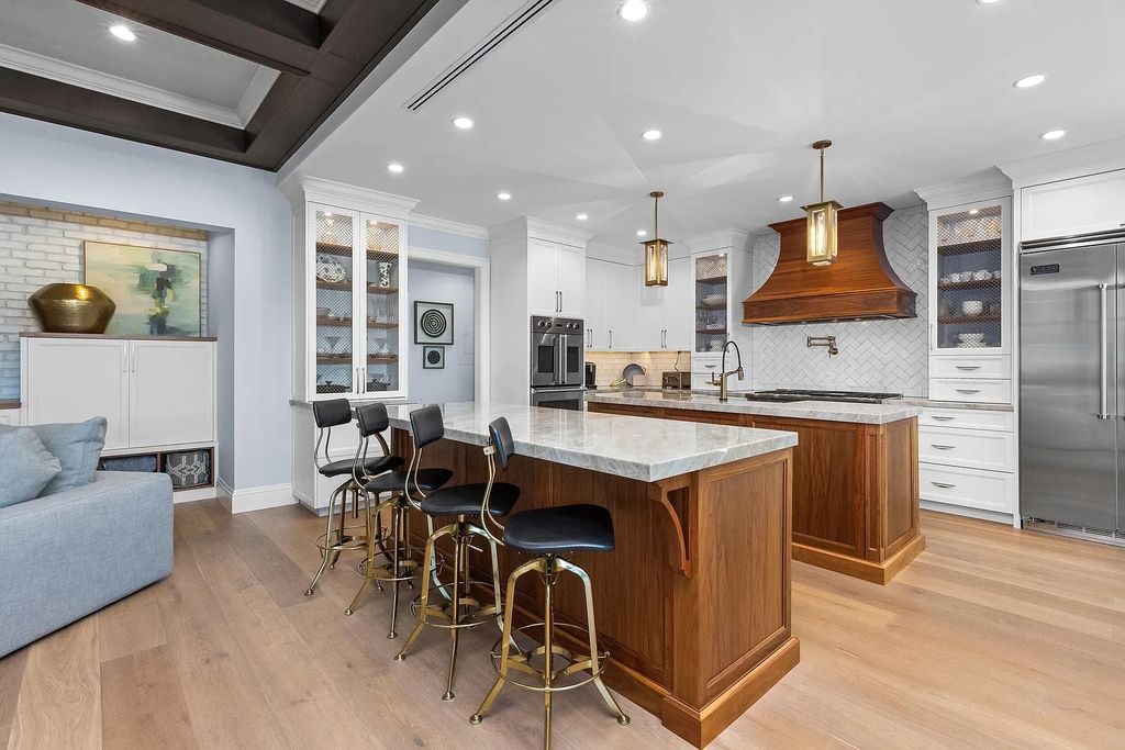 The 3-bedroom main residence features exquisite finishes, including chevron-patterned white oak floors, a striking octagonal living room, and a chef’s kitchen with dual walnut islands, Taj Mahal quartzite countertops, and Viking appliances.