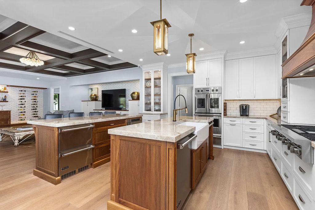 The 3-bedroom main residence features exquisite finishes, including chevron-patterned white oak floors, a striking octagonal living room, and a chef’s kitchen with dual walnut islands, Taj Mahal quartzite countertops, and Viking appliances.