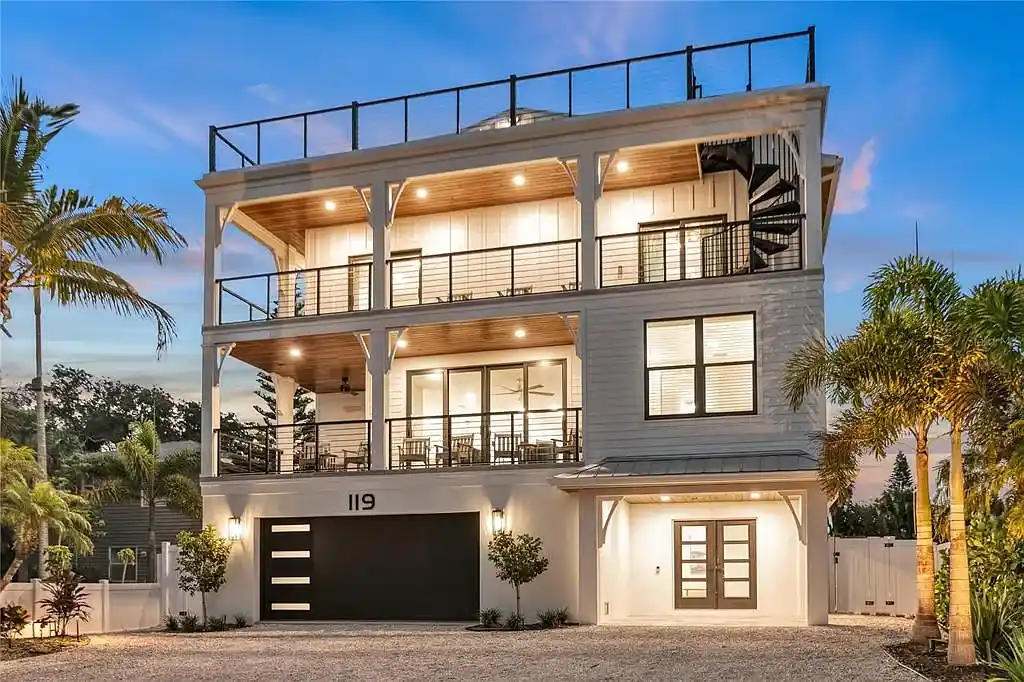 A breathtaking coastal retreat at 119 Avenida Messina, Sarasota, featuring modern architecture, wraparound balconies, and lush tropical landscaping.