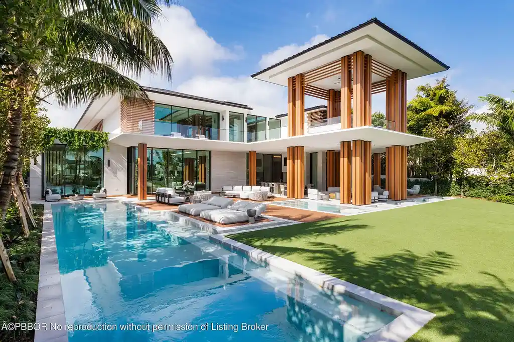 Exterior night view of 2415 Casas De Marbella Dr, highlighting its stunning modern architecture and waterfront setting in Palm Beach Gardens.