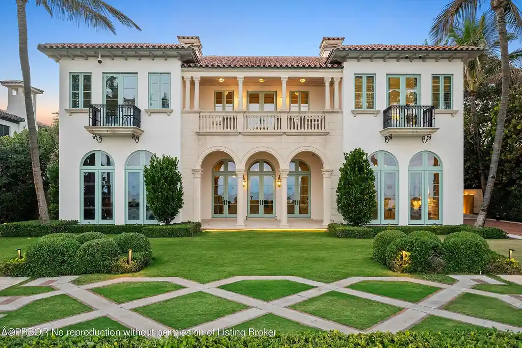 Front view of the Mediterranean-style estate at 516 S Ocean Blvd, Palm Beach, featuring oceanfront access and lush landscaping.