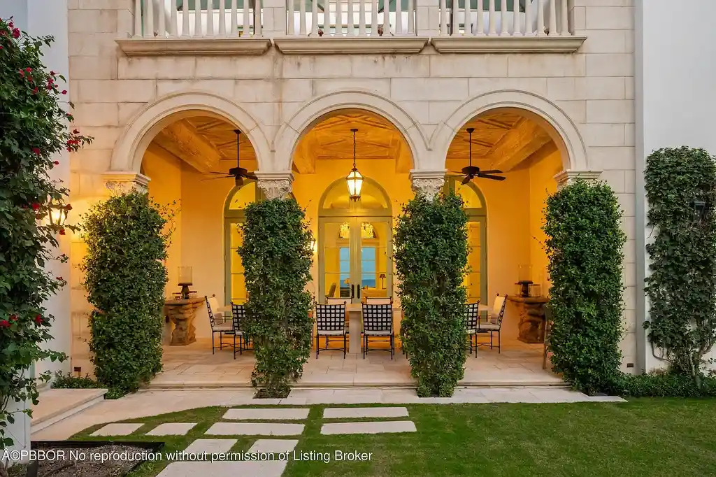 Front view of the Mediterranean-style estate at 516 S Ocean Blvd, Palm Beach, featuring oceanfront access and lush landscaping.