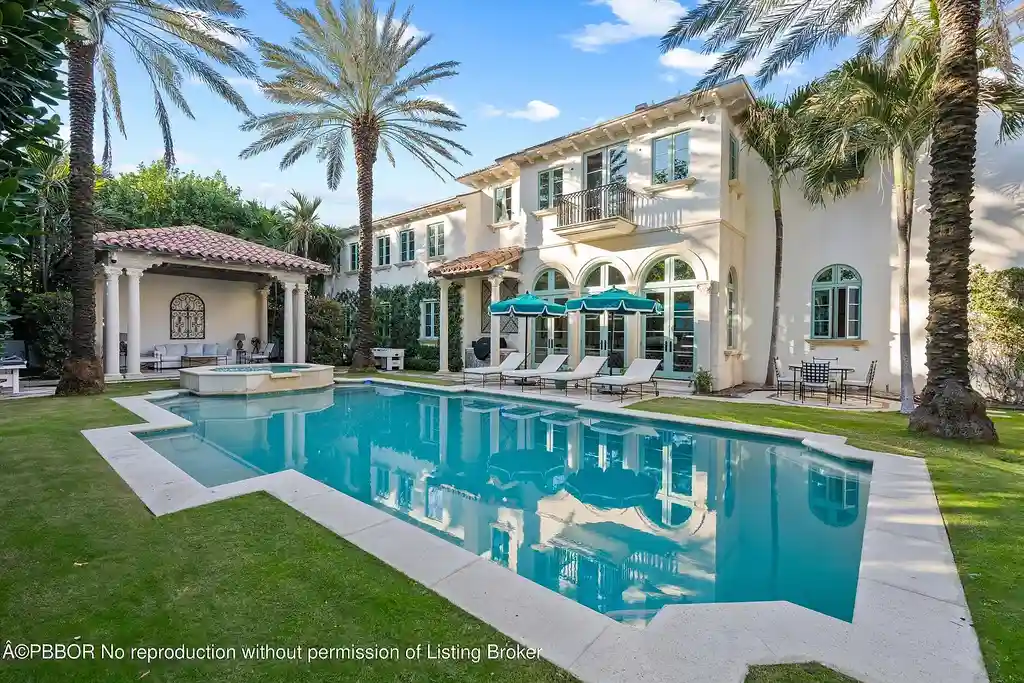 Front view of the Mediterranean-style estate at 516 S Ocean Blvd, Palm Beach, featuring oceanfront access and lush landscaping.