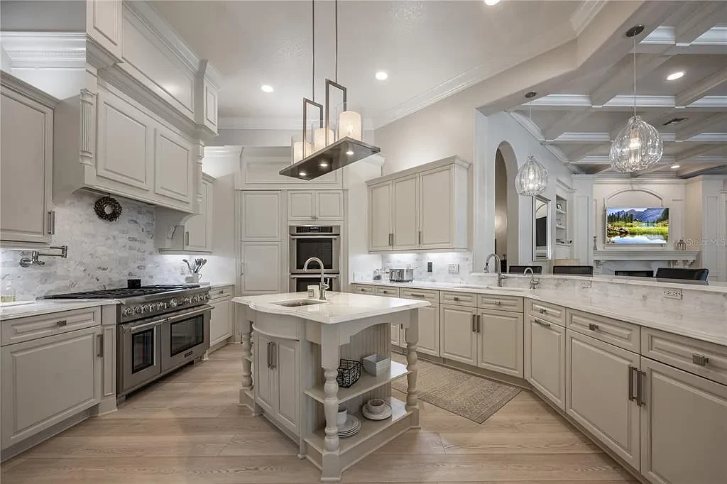 A state-of-the-art kitchen at 6126 Kirkstone Ln, designed with marble countertops, a large center island, and premium appliances.