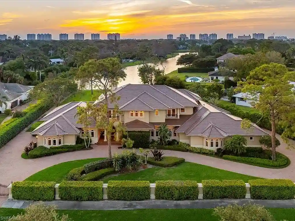 741 Hickory Rd, a luxurious $8.5M estate in Naples, Florida, featuring a stunning architectural design, lakefront views, and lush landscaping.