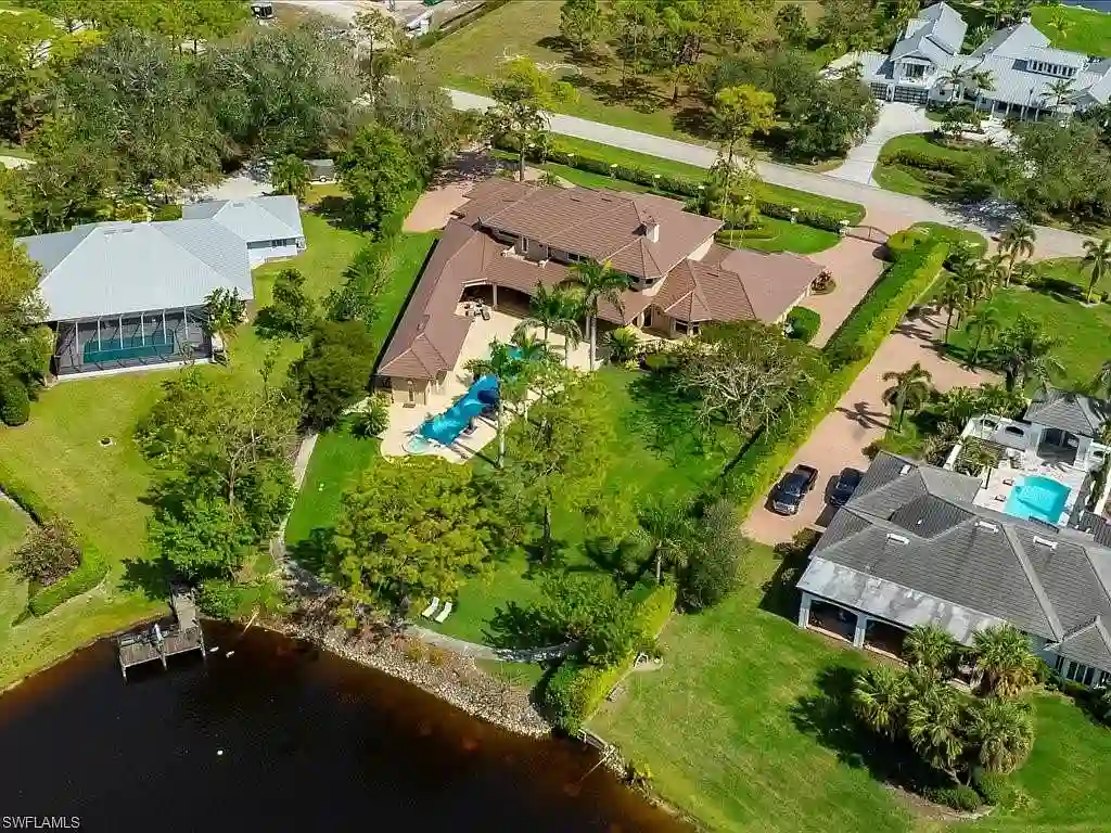 741 Hickory Rd, a luxurious $8.5M estate in Naples, Florida, featuring a stunning architectural design, lakefront views, and lush landscaping.