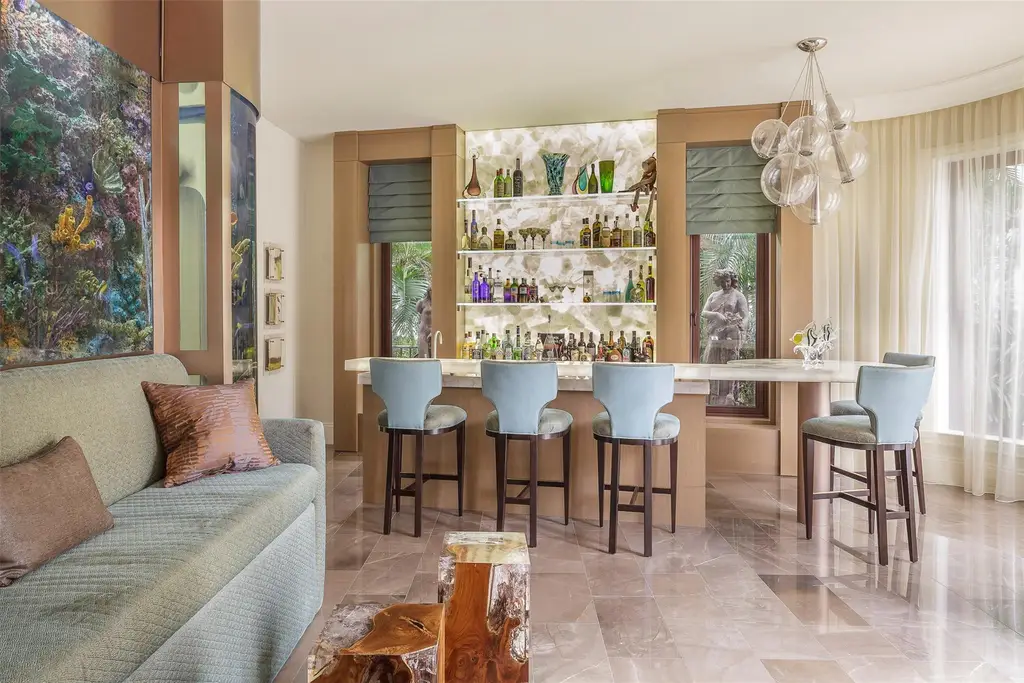 Elegant living room at 815 Idlewyld Dr featuring a gas fireplace, custom onyx bar, and a 1,000-gallon saltwater aquarium.