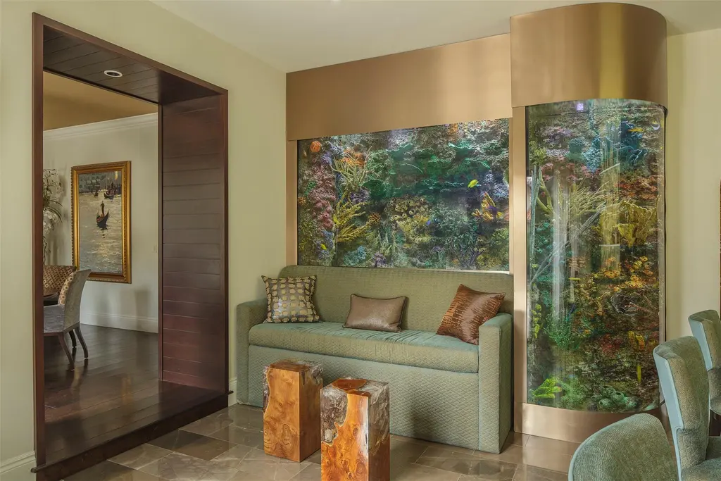 Elegant living room at 815 Idlewyld Dr featuring a gas fireplace, custom onyx bar, and a 1,000-gallon saltwater aquarium.