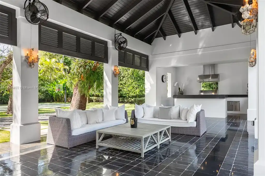 A luxurious $14.97M estate at 8150 SW 52nd Ave, Miami, featuring a heated saltwater pool, gourmet kitchen with Calacatta marble island, and lush landscaped gardens in the exclusive Ponce-Davis neighborhood.