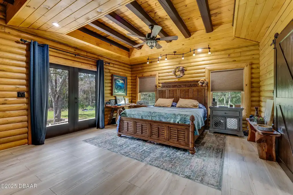 Stunning log cabin estate at 1100 Tallacoe Trl, New Smyrna Beach – a $3.8M rustic retreat with wrap-around porch and expansive countryside views.