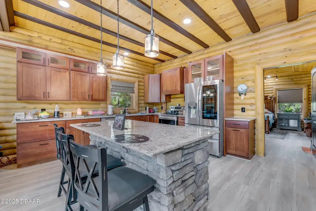 Stunning log cabin estate at 1100 Tallacoe Trl, New Smyrna Beach – a $3.8M rustic retreat with wrap-around porch and expansive countryside views.