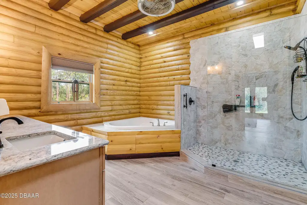 Stunning log cabin estate at 1100 Tallacoe Trl, New Smyrna Beach – a $3.8M rustic retreat with wrap-around porch and expansive countryside views.