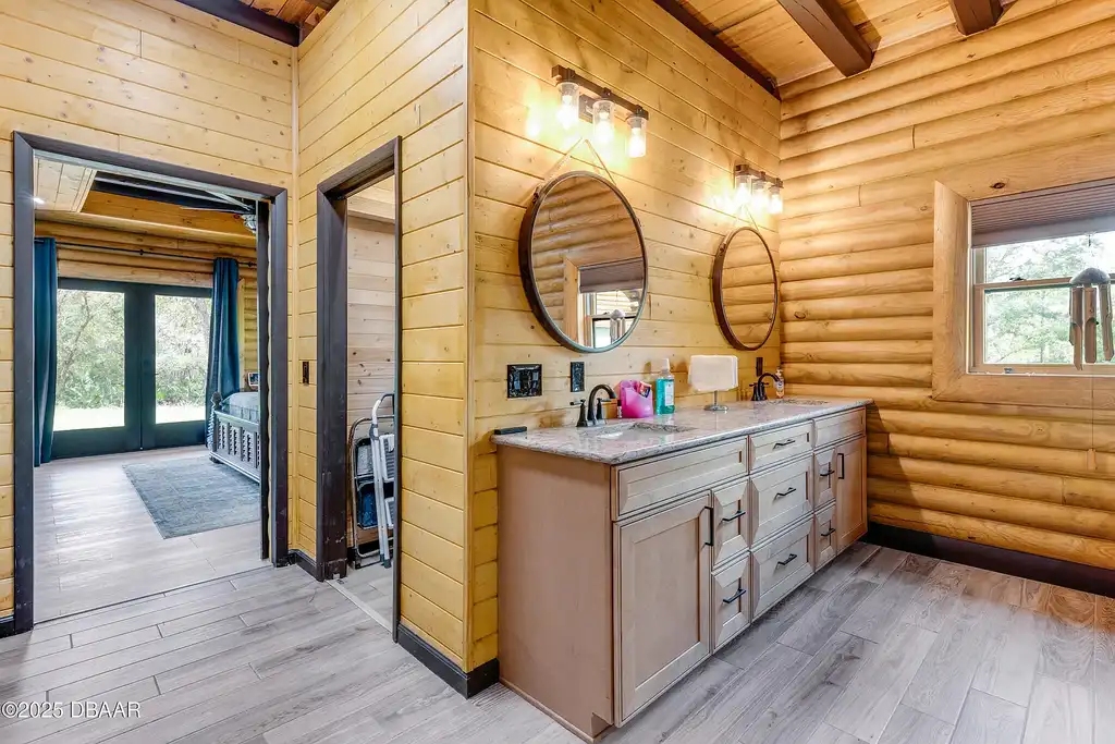 Stunning log cabin estate at 1100 Tallacoe Trl, New Smyrna Beach – a $3.8M rustic retreat with wrap-around porch and expansive countryside views.