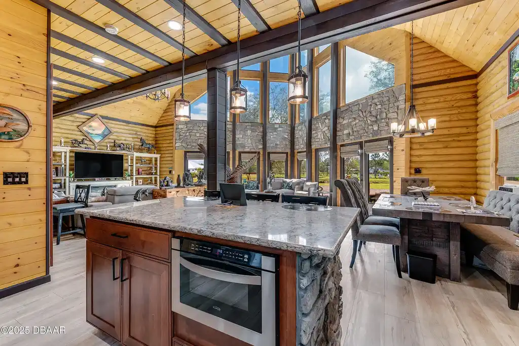 Stunning log cabin estate at 1100 Tallacoe Trl, New Smyrna Beach – a $3.8M rustic retreat with wrap-around porch and expansive countryside views.