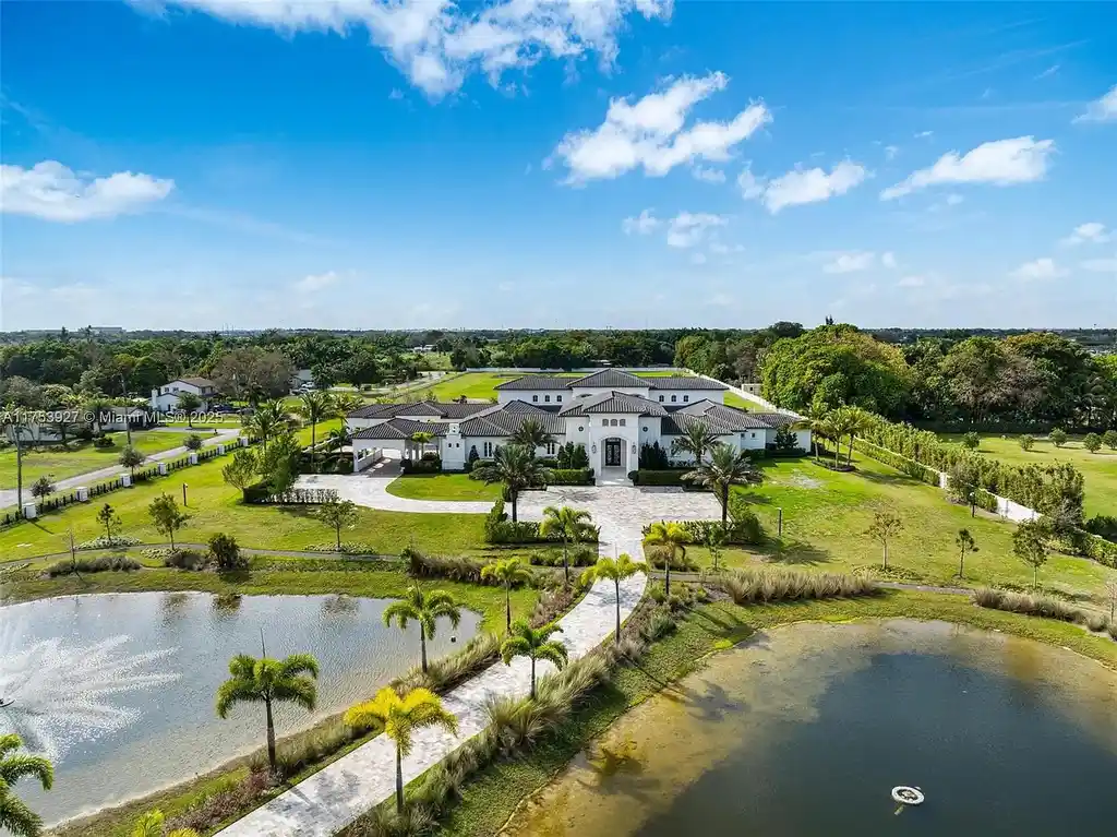 Grand entrance of the $32M estate at 14851 SW 21st St, showcasing synchronized fountains, landscaped gardens, and a resort-style pool house.