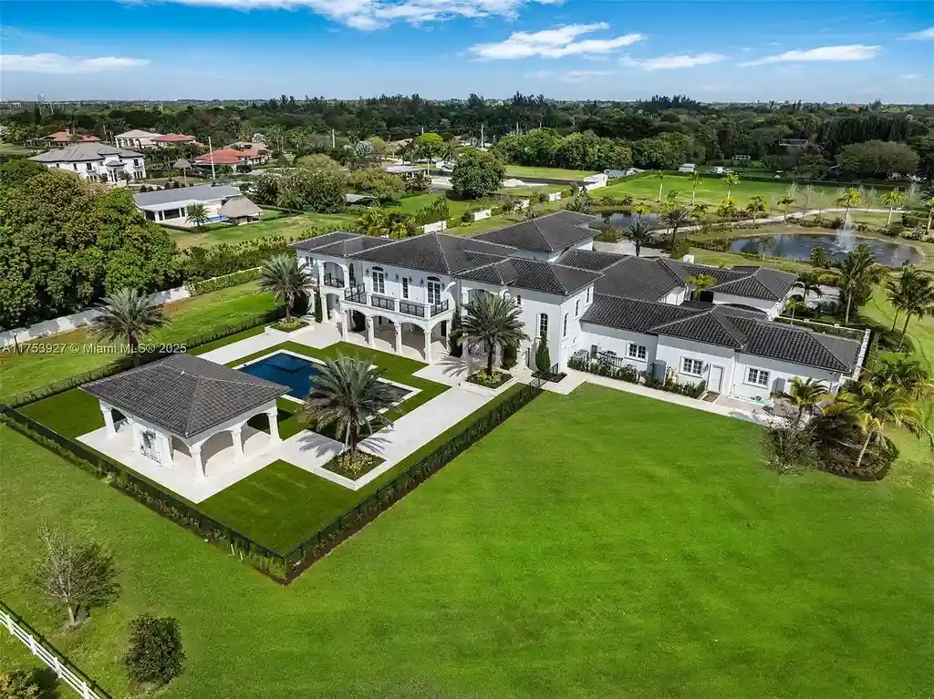 Grand entrance of the $32M estate at 14851 SW 21st St, showcasing synchronized fountains, landscaped gardens, and a resort-style pool house.