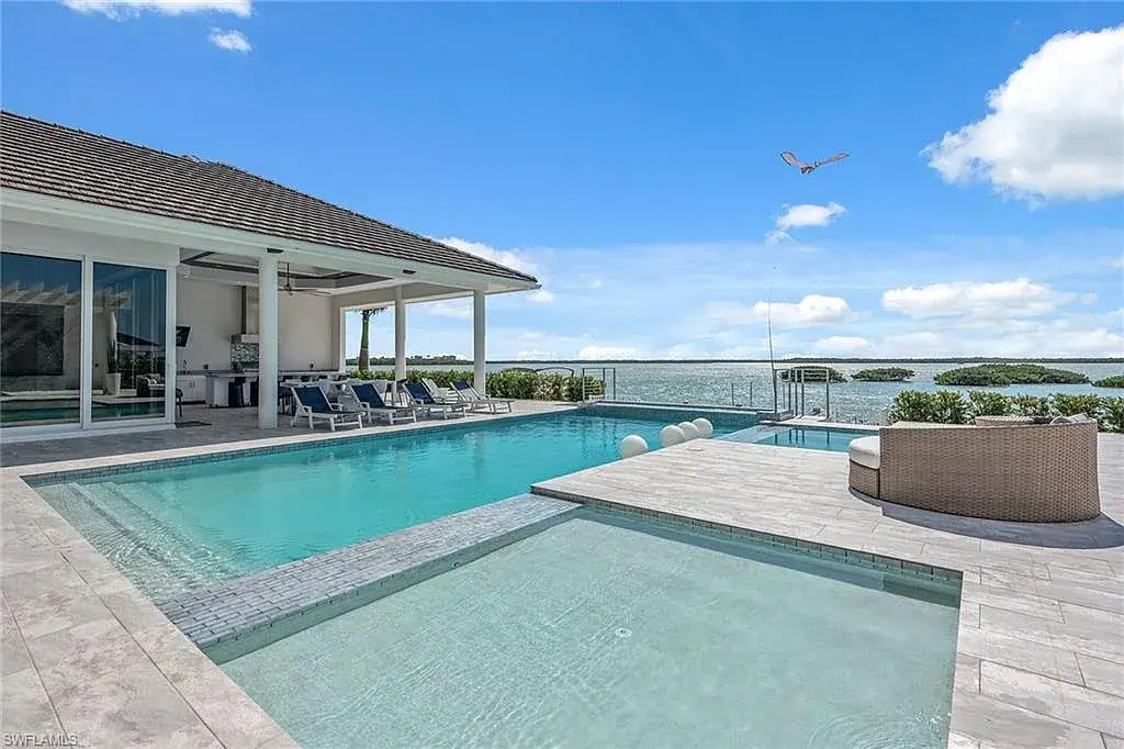 Stunning waterfront estate at 1829 S Inlet Dr, Marco Island, featuring a contemporary coastal design with panoramic Gulf views and lush tropical landscaping.