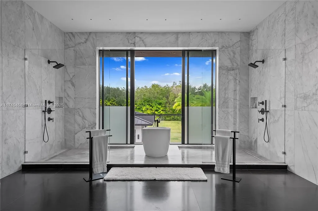 Spacious open-plan living room in 6555 SW 102nd St, featuring double-height ceilings, elegant marble floors, and floor-to-ceiling windows with natural light.