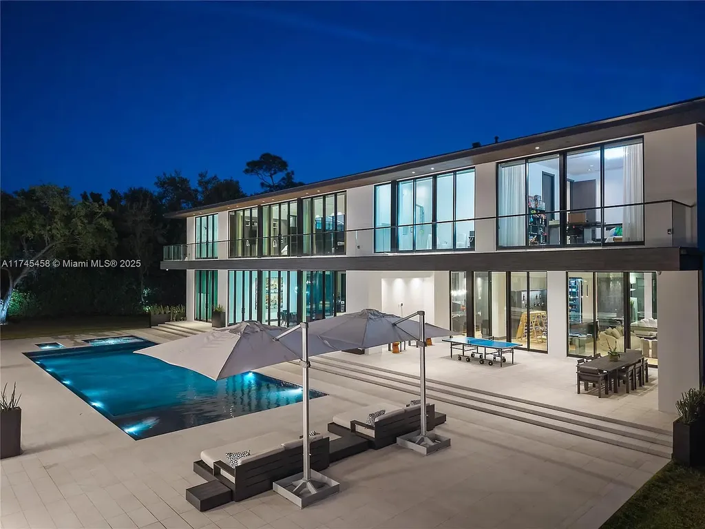 Spacious open-plan living room in 6555 SW 102nd St, featuring double-height ceilings, elegant marble floors, and floor-to-ceiling windows with natural light.