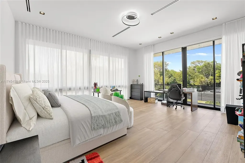 Spacious open-plan living room in 6555 SW 102nd St, featuring double-height ceilings, elegant marble floors, and floor-to-ceiling windows with natural light.