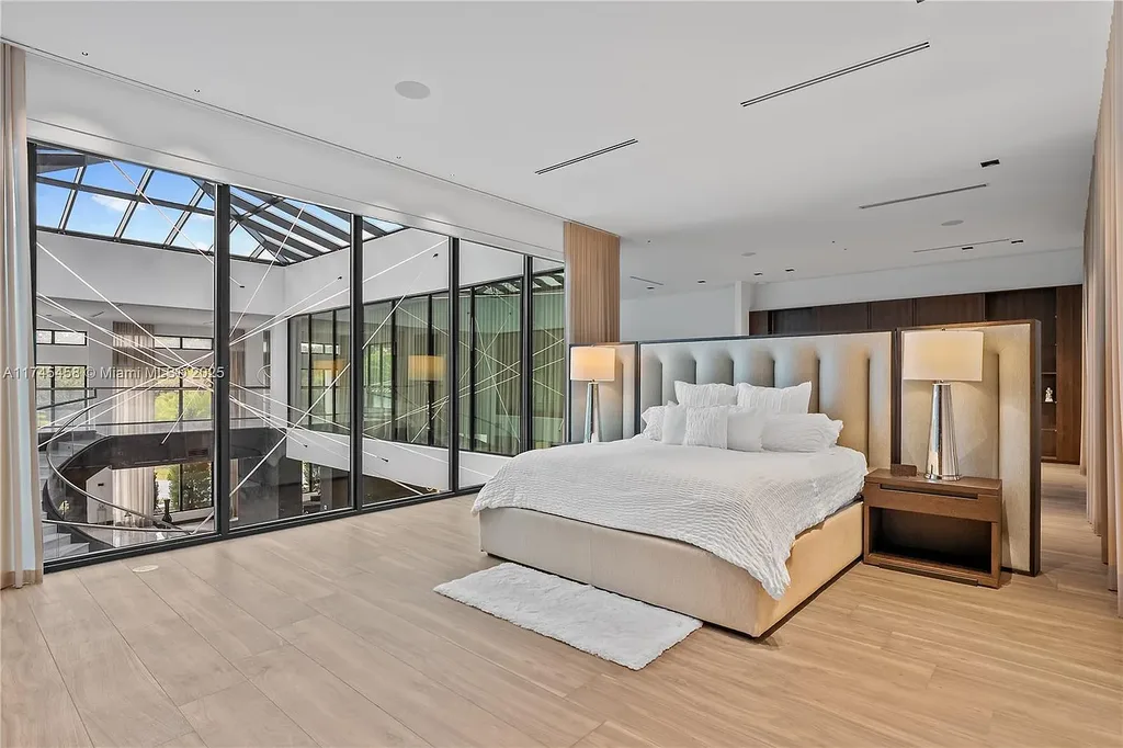 Spacious open-plan living room in 6555 SW 102nd St, featuring double-height ceilings, elegant marble floors, and floor-to-ceiling windows with natural light.