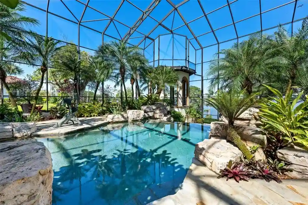 Luxury lakefront estate at 11865 Fort King Hwy in Thonotosassa, Florida, featuring Mediterranean architecture, private dock, Oval Office replica, and tiered pool.