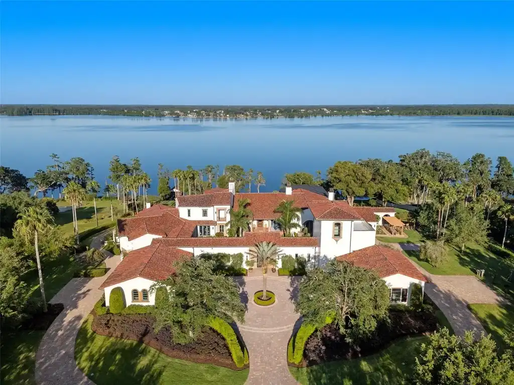 Luxury lakefront estate at 11865 Fort King Hwy in Thonotosassa, Florida, featuring Mediterranean architecture, private dock, Oval Office replica, and tiered pool.