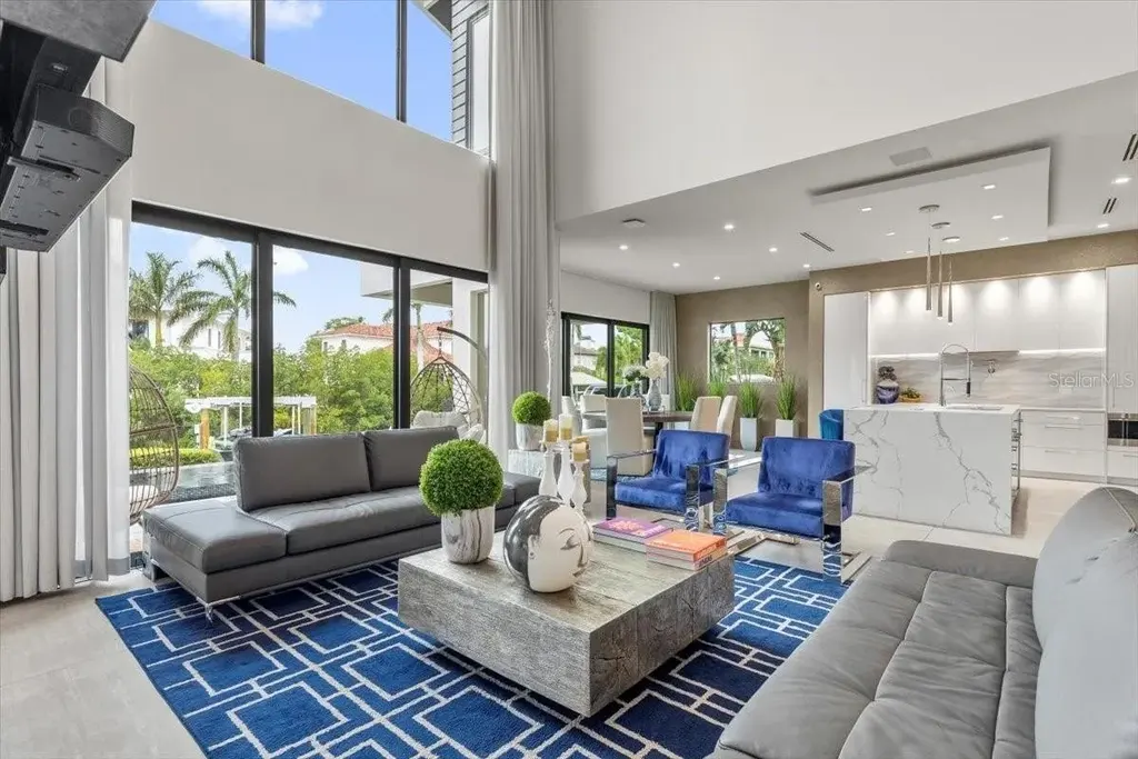 Luxury waterfront estate at 5131 W Neptune Way, Tampa featuring modern architecture, private dock, saltwater pool, rooftop terrace, and smart home technology