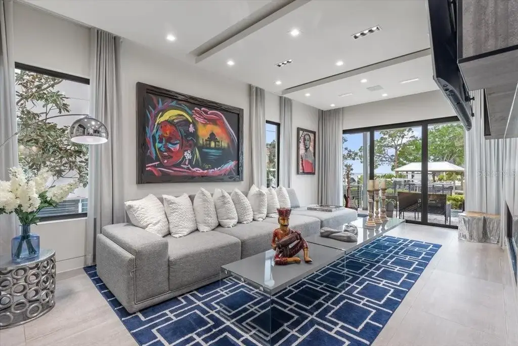 Luxury waterfront estate at 5131 W Neptune Way, Tampa featuring modern architecture, private dock, saltwater pool, rooftop terrace, and smart home technology