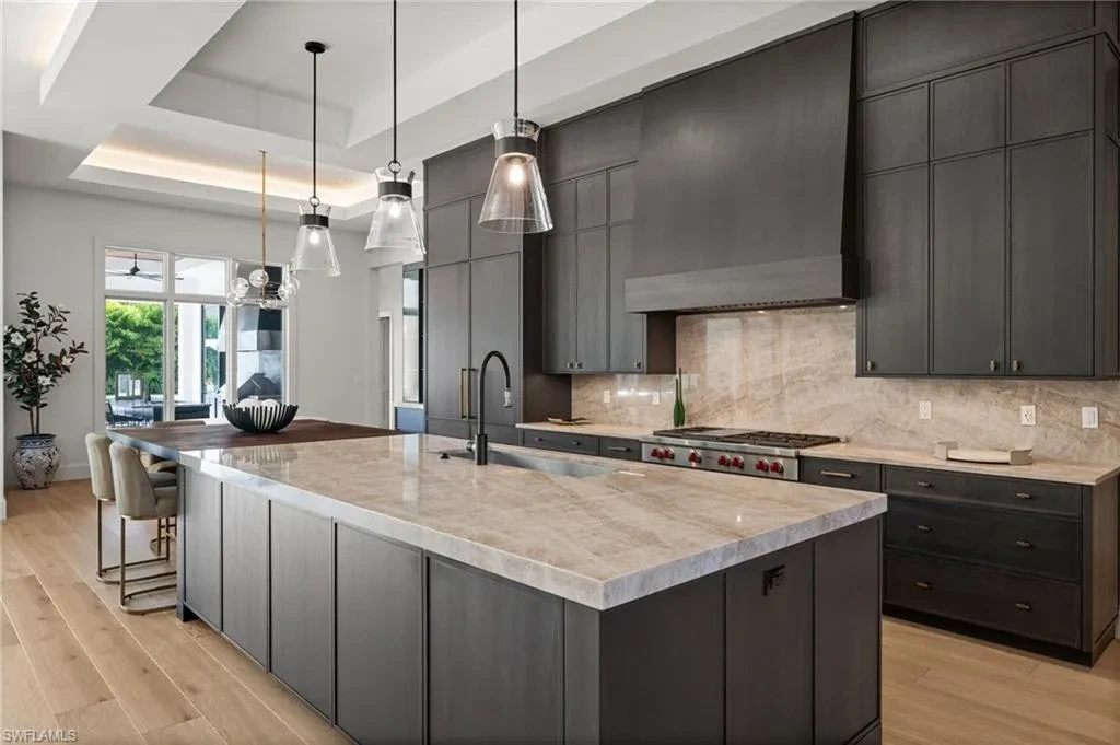 Luxury estate at 115 East Ave in Naples featuring outdoor kitchen, screened lanai, fire pit, and heated saltwater pool within Pine Ridge Estates