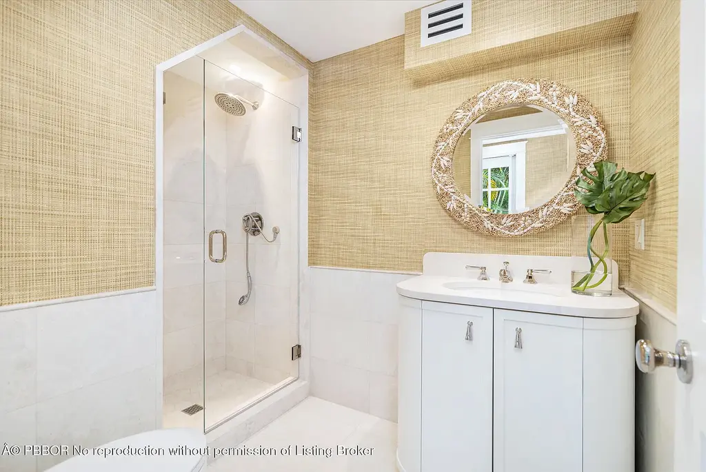 Elegant front view of the renovated $13.5M bungalow-style home at 142 Seabreeze Ave, Palm Beach, featuring guesthouse, heated pool, and lush landscaping